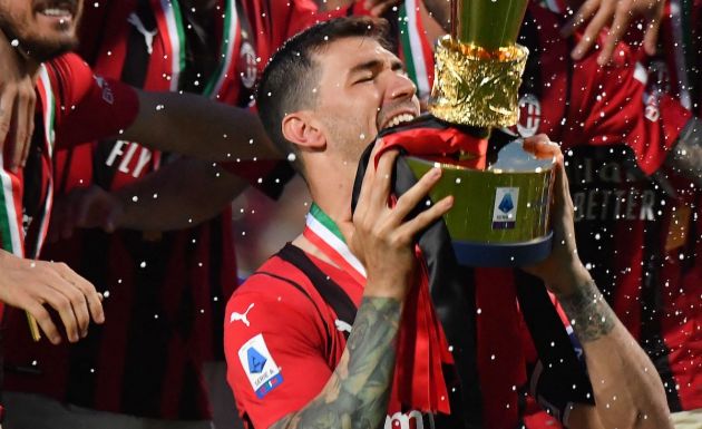 AC Milan defender and Lazio linked Alessio Romagnoli bites the cup as AC Milan's players celebrate with the winner's trophy after AC Milan won the Italian Serie A football match between Sassuolo and AC Milan, securing the "Scudetto" championship on May 22, 2022 at the Mapei - Citta del Tricolore stadium in Sassuolo. (Photo by Tiziana FABI / AFP) (Photo by TIZIANA FABI/AFP via Getty Images)