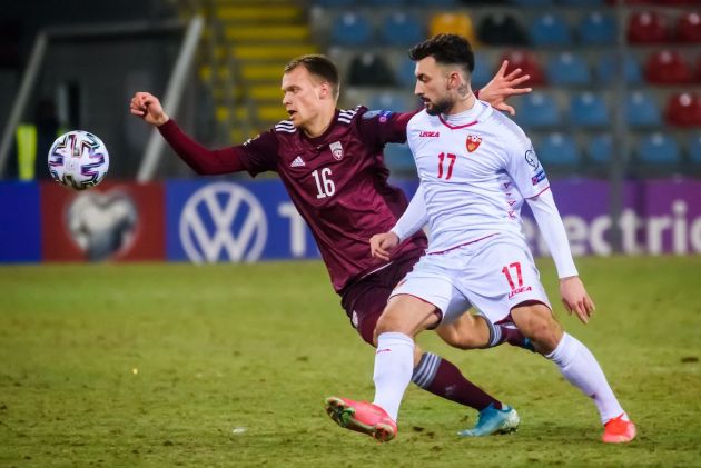 Latvia Alvis Jaunzems (L) and Montenegro midfielder Sead Haksabanovic vie for the ball during the FIFA World Cup Qatar 2022 qualification football match Latvia v Montenegro in Riga, on March 24, 2021. (Photo by Gints Ivuskans / AFP) (Photo by GINTS IVUSKANS/AFP via Getty Images)