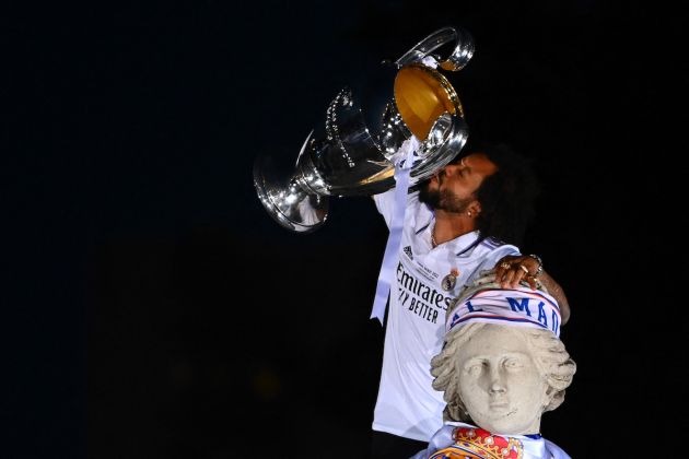 Real Madrid defender Marcelo kisses their trophy ontop of the statue of Greek goddess Cybele on May 29, 2022 at the Cibeles square in Madrid, a day after beating Liverpool in the UEFA Champions League final in Paris. - Real Madrid claimed a 14th European Cup as Vinicius Junior's goal saw them beat Liverpool 1-0 in the Champions League final at the Stade de France amid chaotic scenes yesterday. (Photo by GABRIEL BOUYS / AFP) (Photo by GABRIEL BOUYS/AFP via Getty Images)