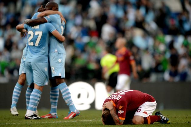 AS Roma midfielder Daniele De Rossi (R) reacts as Lazio players celebrate victory over AS Roma on May 26, 2013 at the end of the Italian Cup football final at the Olympic Stadium in Rome. AFP PHOTO / FILIPPO MONTEFORTE (Photo credit should read FILIPPO MONTEFORTE/AFP via Getty Images)